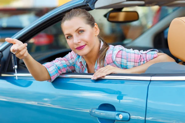 Jovem mulher sentada em um carro conversível com as chaves na mão — Fotografia de Stock