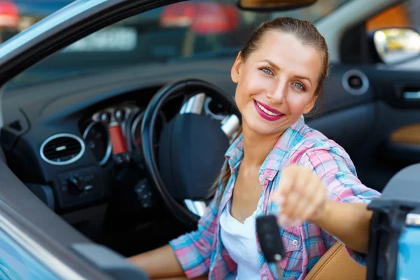 Jovem mulher sentada em um carro conversível com as chaves na mão  - — Fotografia de Stock