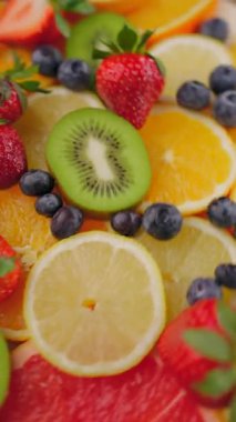 Meyveli taze meyve dilimlerinin arka planı. Dönüşümlü yaz meyve parçaları. Diyet, diyet, sağlıklı vejetaryen yemekleri. Vejetaryen tatlı yiyecekler, düz uzanma. Dikey