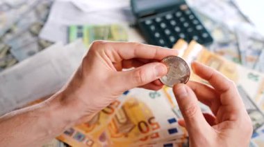 Erkek eli, farklı para birimlerinin -dolar ve avro- arka planında gümüş ve altın BTC bitcoin gösteriyor. Kripto para birimi kavramı ve engin blok zinciri dünyası.