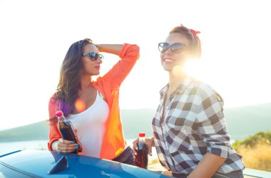 İki genç kız açık havada cabriolet eğleniyor