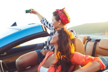 İki genç güzel kız selfie üstü açık bir araba içinde yapıyorsun