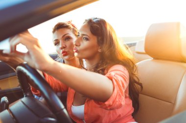İki genç güzel kız selfie üstü açık bir araba içinde yapıyorsun