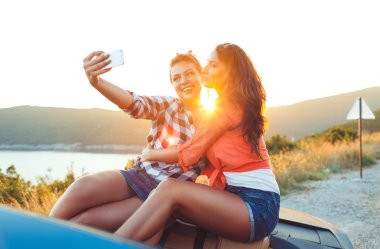 İki genç güzel kız selfie üstü açık bir araba içinde yapıyorsun