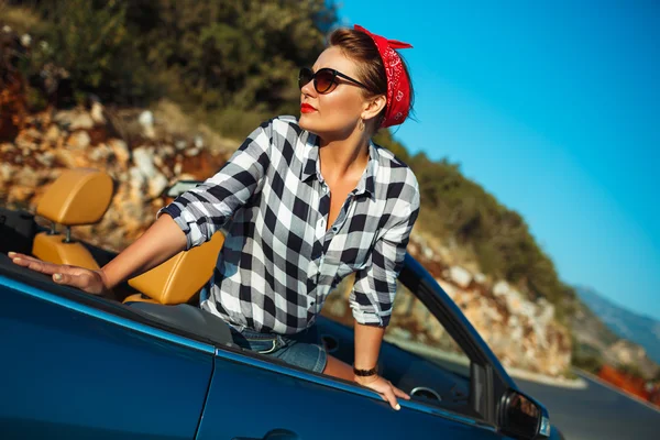 Mooie pin-up vrouw zitten in cabriolet, genieten van de reis op lu — Stockfoto