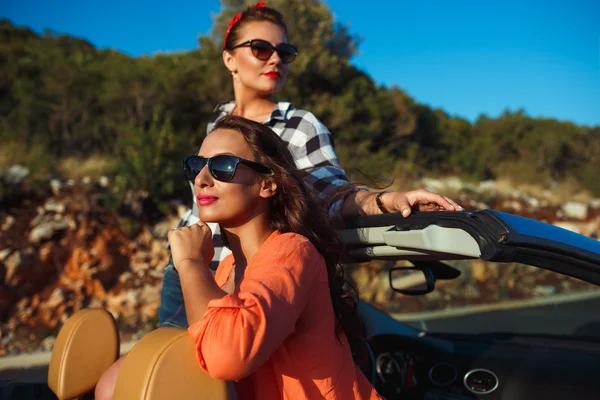 Two young girls having fun in the cabriolet outdoors — Stock Photo, Image