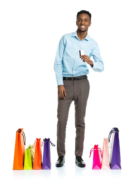 Homem americano africano feliz com sacos de compras e segurando crédito — Fotografia de Stock