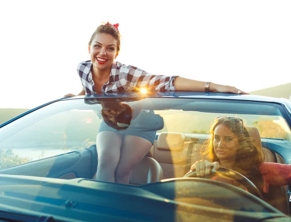 Två unga tjejer kör en cabriolet — Stockfoto