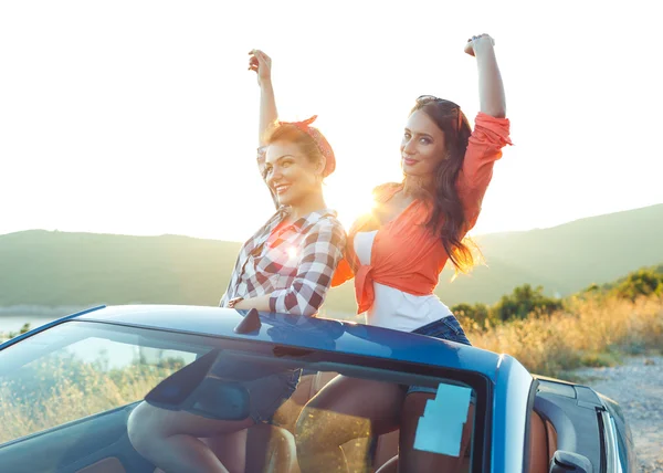 İki genç kız açık havada cabriolet eğleniyor