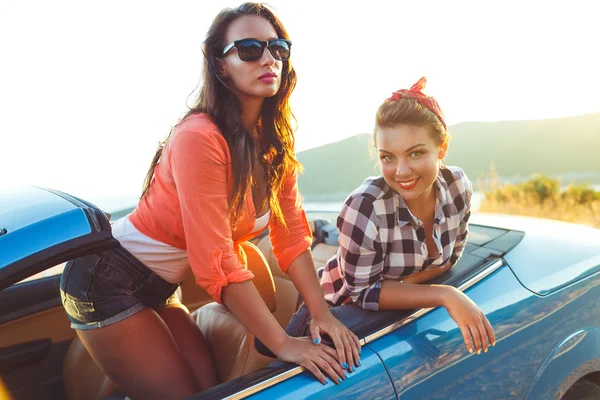 Две молодые девушки веселятся в кабриолете на открытом воздухе — стоковое фото