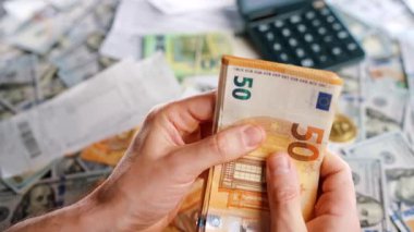 Ev muhasebesi konsepti. Adam para sayıyor, aylık konut giderleri, vergiler ve kredi kartı faturaları. Yavaş çekim