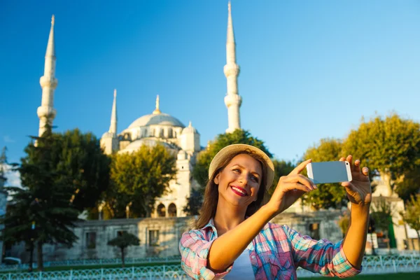 Flicka i hatten att göra selfie av smartphone på bak — Stockfoto