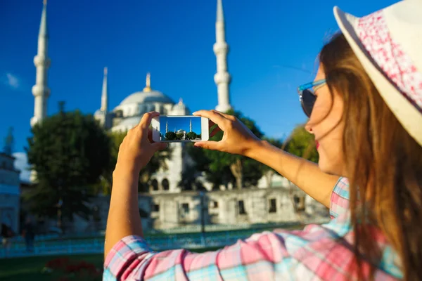 Girl in the hat making photo by the smartphone near the Blue Mos — Stockfoto