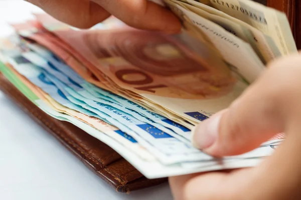 Vrouw openen bruinleren portemonnee vol van eurobankbiljetten — Stockfoto