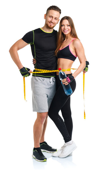 Счастливая атлетическая пара с мерной лентой и бутылкой воды на
