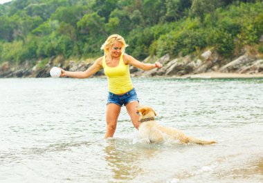 Plajda oynayan köpek kadınla