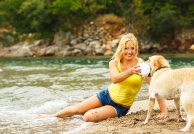 Plajda oynayan köpek kadınla