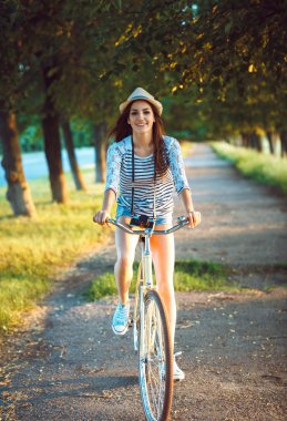 Güzel bayanı şapkalı bir parkta Bisiklete binmek bir