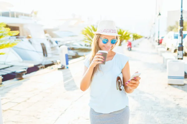 유행 여자 테이크 아웃 커피를 마시고는 waterfr에 산책 — 스톡 사진