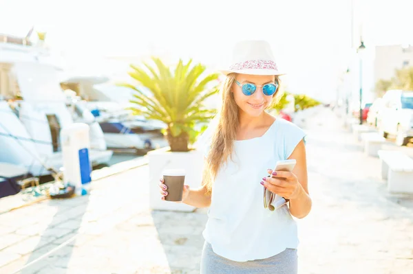 Mujer de moda tomando café para llevar y caminando en el waterfr —  Fotos de Stock