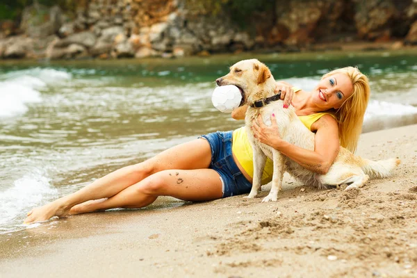 Mulher com cão brincando na praia — Fotografia de Stock