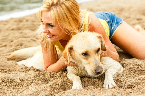 Woman with dog playing on the beach — Stock Photo, Image