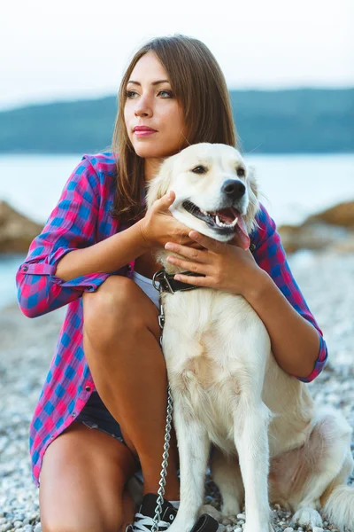 Mulher com um cão em um passeio na praia — Fotografia de Stock