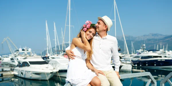 Atraente jovem casal andando ao lado da marina com amarrado — Fotografia de Stock