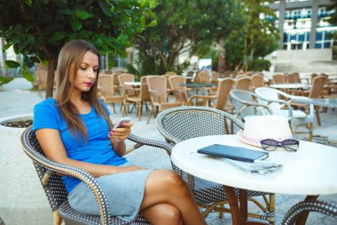 Açık kafede dinlendirici ve smartp kullanarak genç güzel kadın