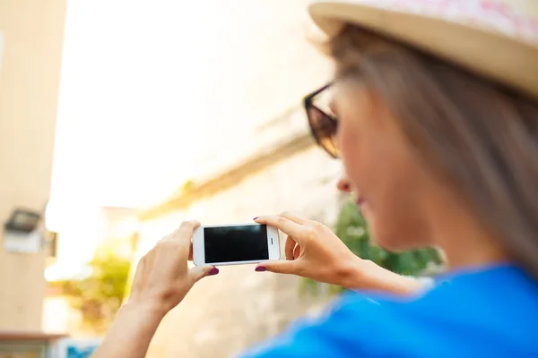 Chica en sombrero haciendo fotos de una iglesia por el teléfono inteligente — Foto de Stock