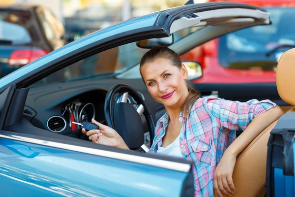 Giovane bella donna seduta in una macchina cabriolet con le chiavi in — Foto Stock