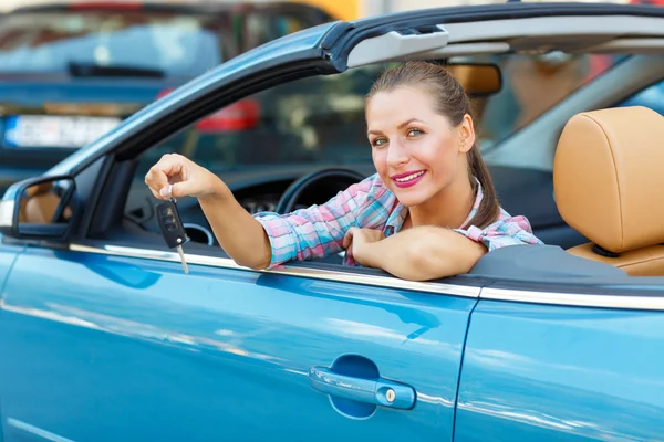 Ung vacker kvinna sitter i en cabriolet bil med nycklarna i — Stockfoto