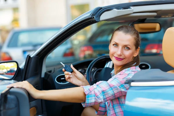 Giovane bella donna seduta in una macchina cabriolet con le chiavi in — Foto Stock