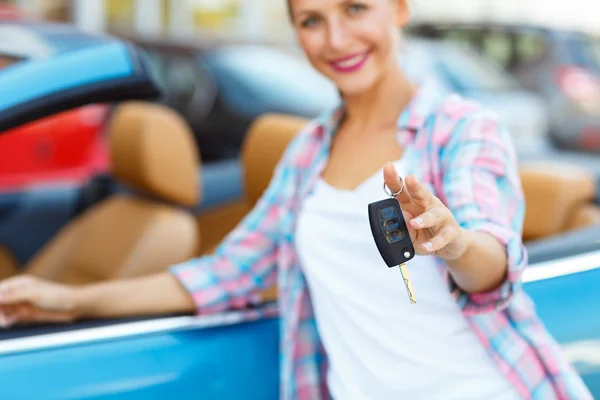Junge Frau steht neben einem Cabrio mit Schlüssel in der Hand — Stockfoto