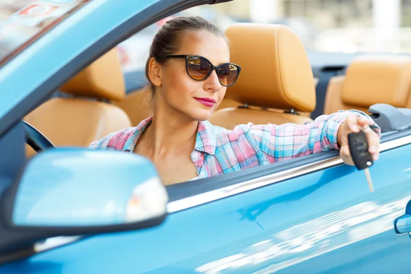 Mujer bonita joven en gafas de sol sentado en un coche convertible wi —  Fotos de Stock