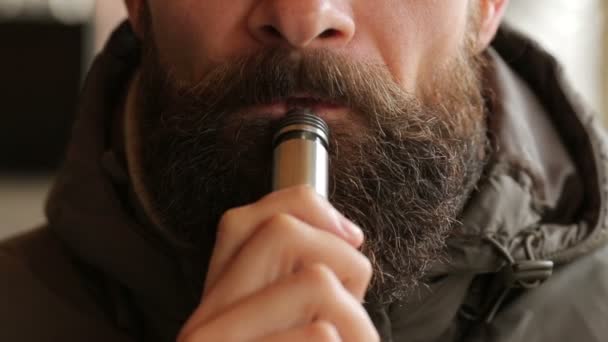 Bärtiger Mann, der elektronische Zigarette raucht — Stockvideo