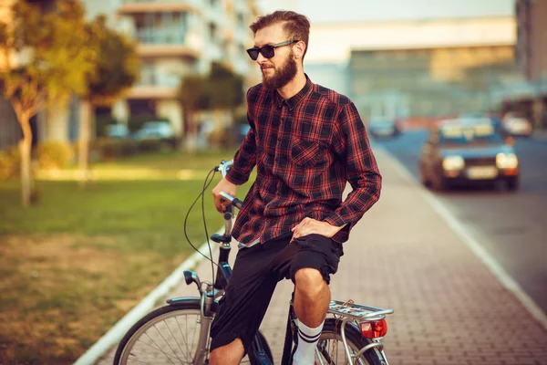 Uomo in occhiali da sole in bicicletta sulla strada della città — Foto Stock