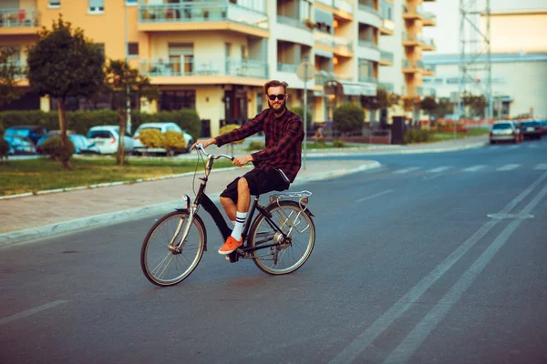 Uomo in occhiali da sole in bicicletta sulla strada della città — Foto Stock