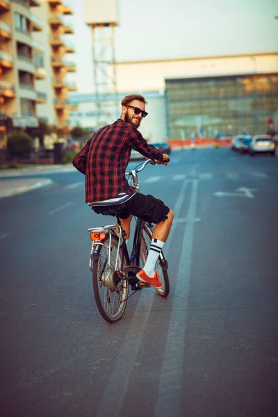 Uomo in occhiali da sole in bicicletta sulla strada della città — Foto Stock