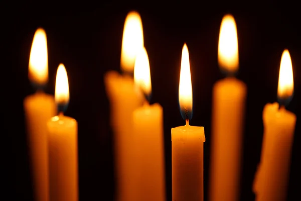 Viele brennende Kerzen auf schwarz — Stockfoto