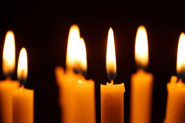 Viele brennende Kerzen auf schwarz — Stockfoto