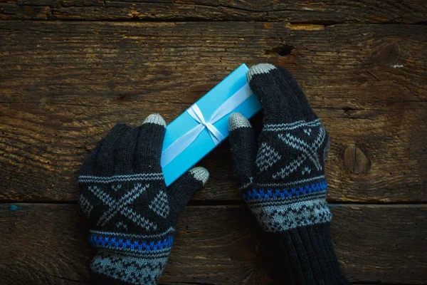 Mains dans les gants d'hiver avec boîte cadeau de Noël — Photo