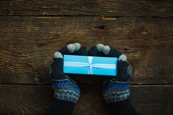 Manos en guantes de invierno con caja de regalo de Navidad — Foto de Stock