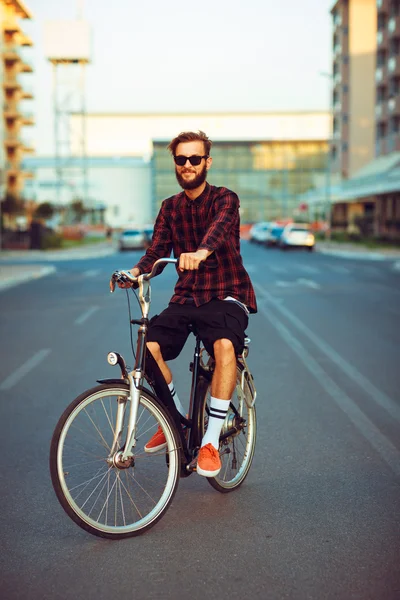 Uomo elegante in occhiali da sole in bicicletta sulla strada della città — Foto Stock