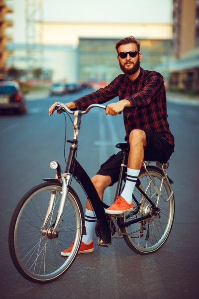 Uomo elegante in occhiali da sole in bicicletta sulla strada della città — Foto Stock