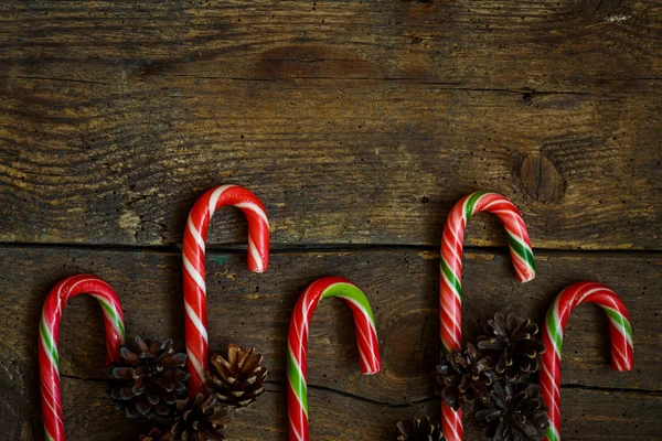 Bordure de Noël avec cônes et canne à bonbons sur des planches en bois — Photo