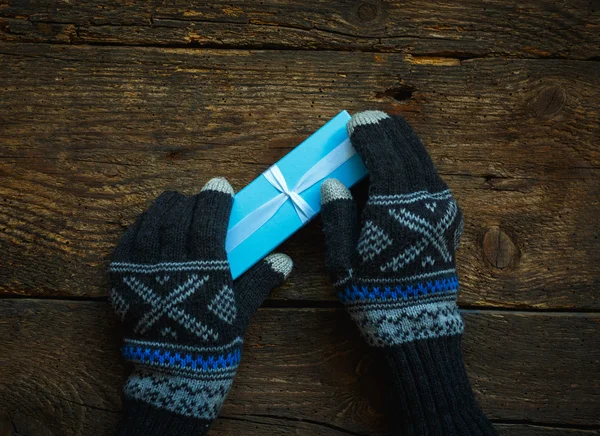 Hände in Winterhandschuhen mit Weihnachtsgeschenkschachtel — Stockfoto