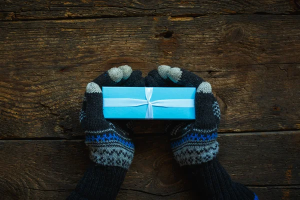 Τα χέρια σε χειμερινά γάντια με κιβώτιο δώρων Χριστουγέννων — Φωτογραφία Αρχείου