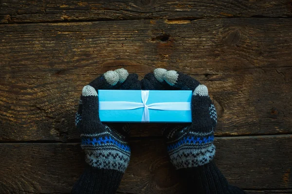 Mãos em luvas de inverno com caixa de presente de Natal — Fotografia de Stock