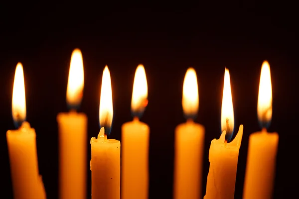 Mnoho hořící svíčky na černém pozadí — Stock fotografie